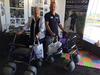 a photo of an older lady and middle aged man standing with beach walkers at our expo booth