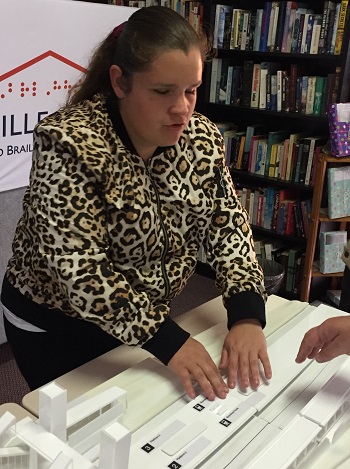 a Photo of Hailey tactually exploring a hands on three d map of Fairfield railway station