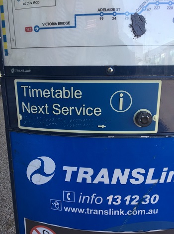 a photo of A close up image of a bus timetable announcer button, including accessible signage